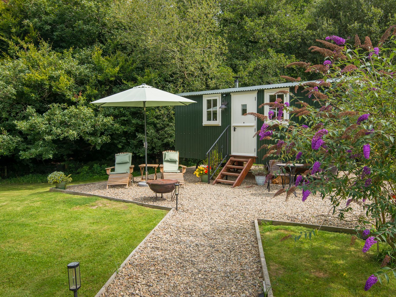 An outdoor area with a green cabin and seating at Collen in Aberaeron