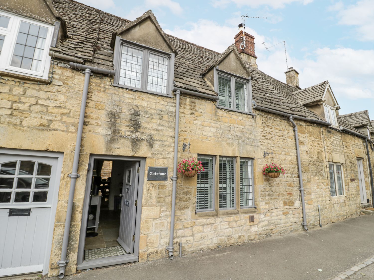 A stone building with a door and window at Cotstone Cottage in Chipping Campden