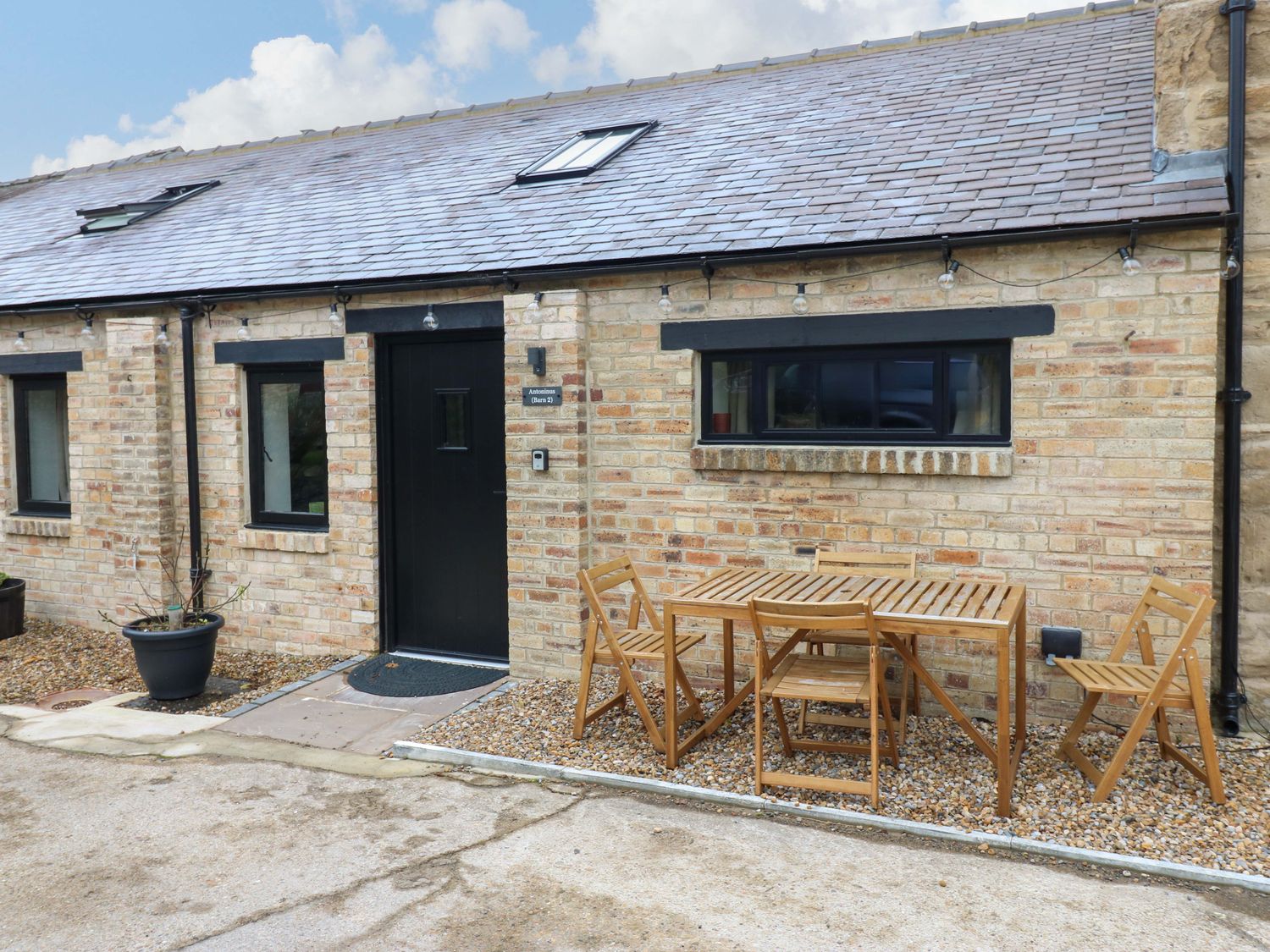 An outdoor seating area with a table and chairs at Antoninus Barn 2 in Ebchester