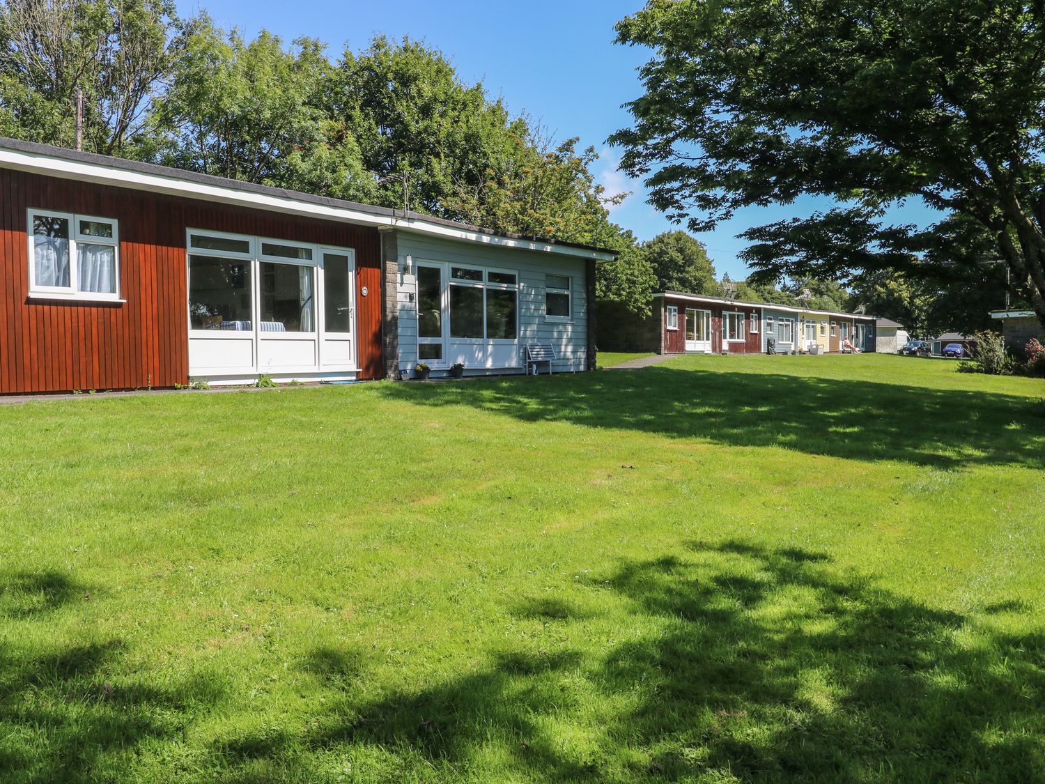 A row of single-story houses with lawns and trees at 61 Norton Park in Dartmouth