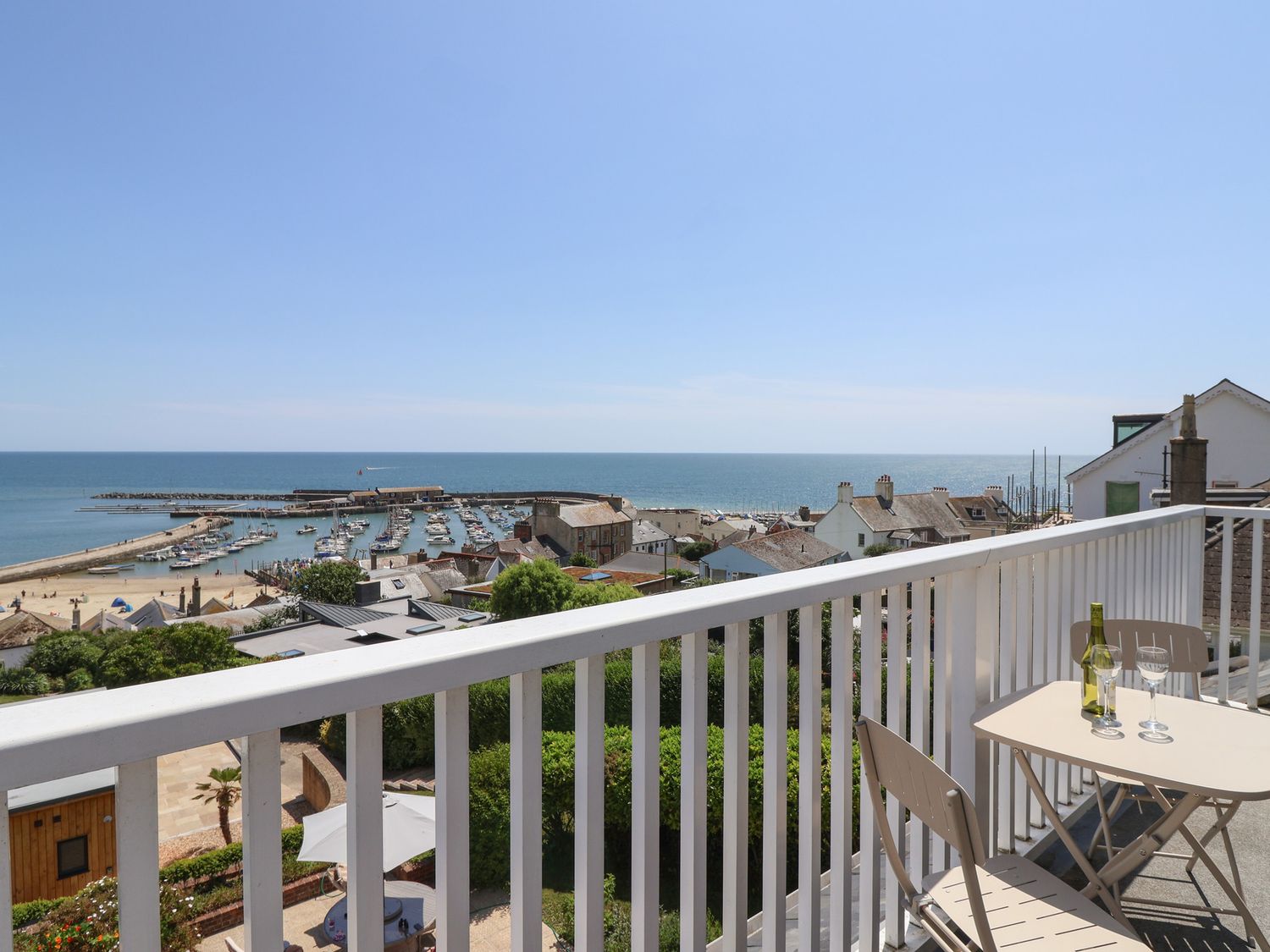 A balcony view overlooking the ocean and harbor at 3 Harbour Heights Lyme Regis