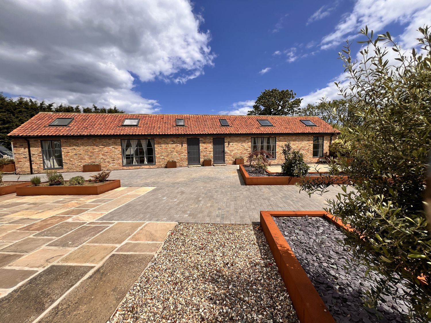 A house with paved area and plant beds at Sabi Gembling near Beeford