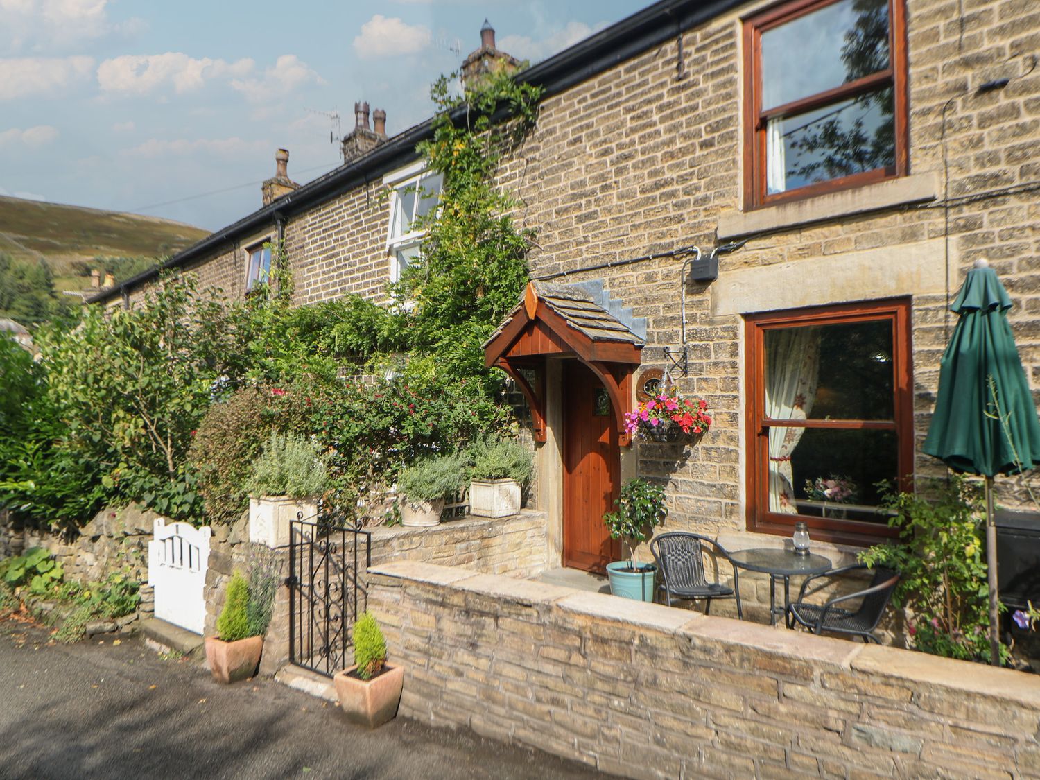 An outdoor area with a table and chairs at Brook Cottage in Hayfield, High Peak