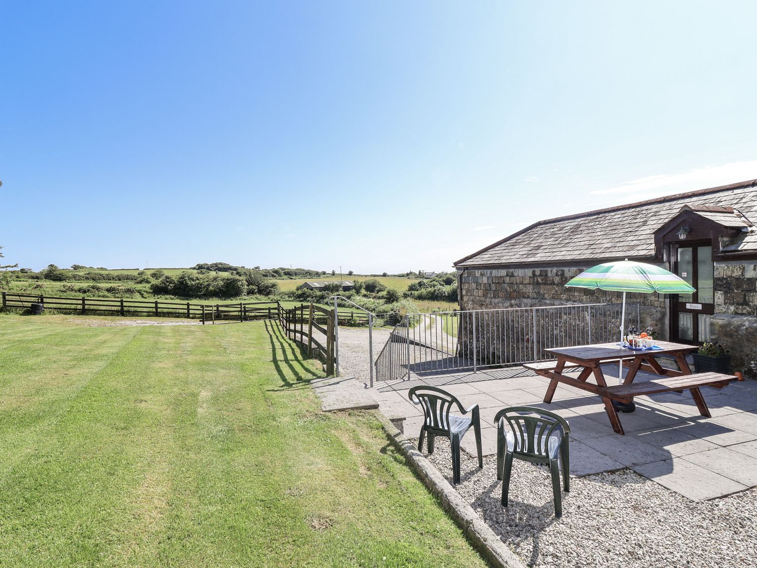 An outdoor area with a table and chairs at The Byre in Common Moor near Liskeard