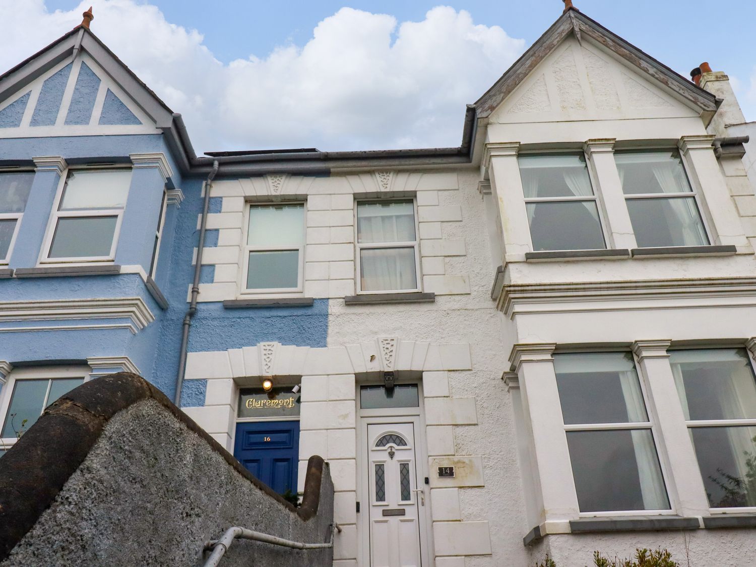 Exterior of two attached houses with one having a blue door marked 16 and the other a white door marked 14 Beech Road St Austell