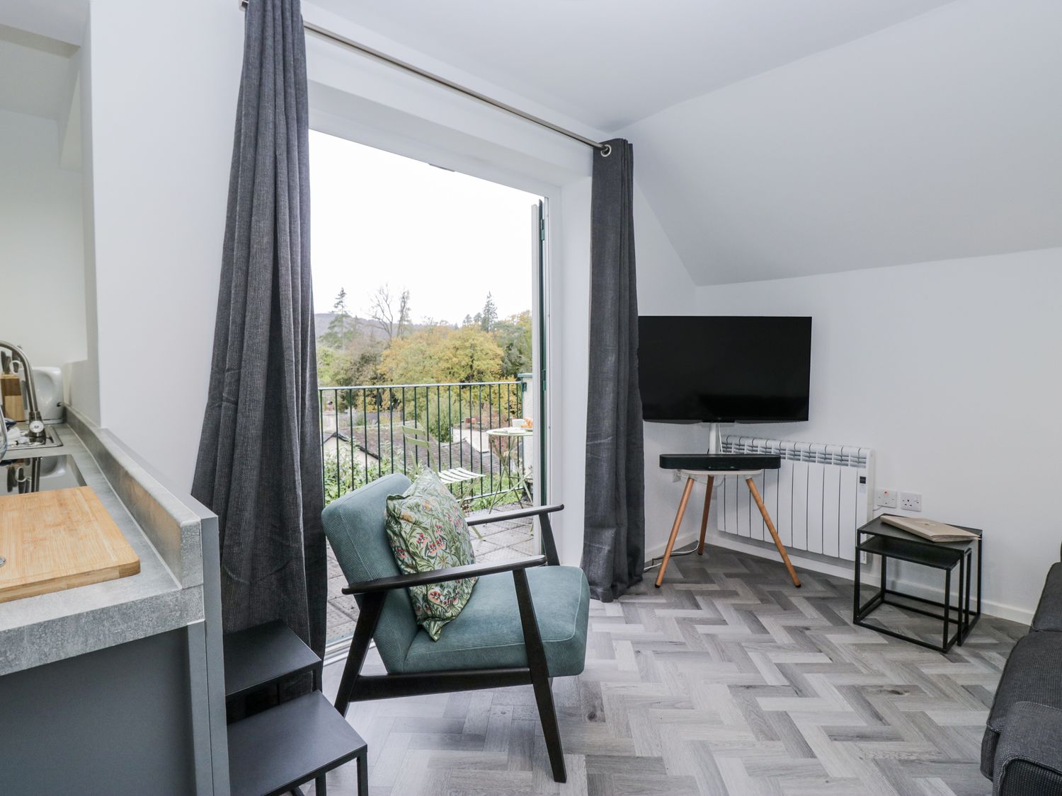 A living room with a television and sofa at Claife Flights in Bowness-On-Windermere