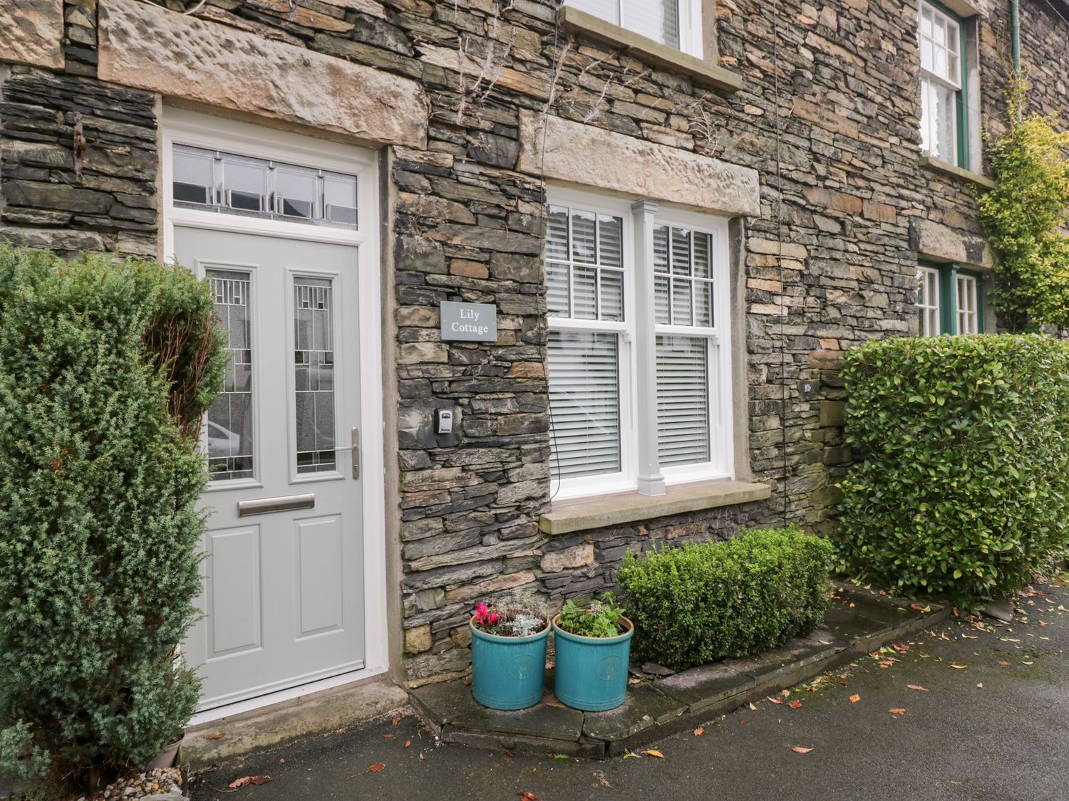 A front entrance of a cottage with plants at Lily Cottage in Windermere