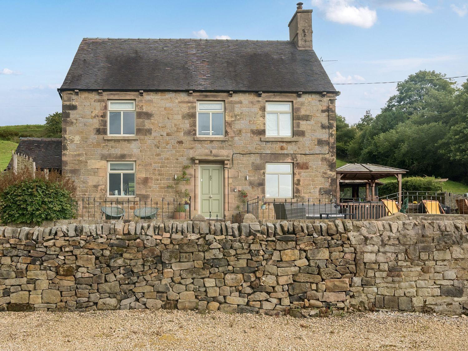 A house with a stone wall and garden at HollyDale in Bradnop near Leek