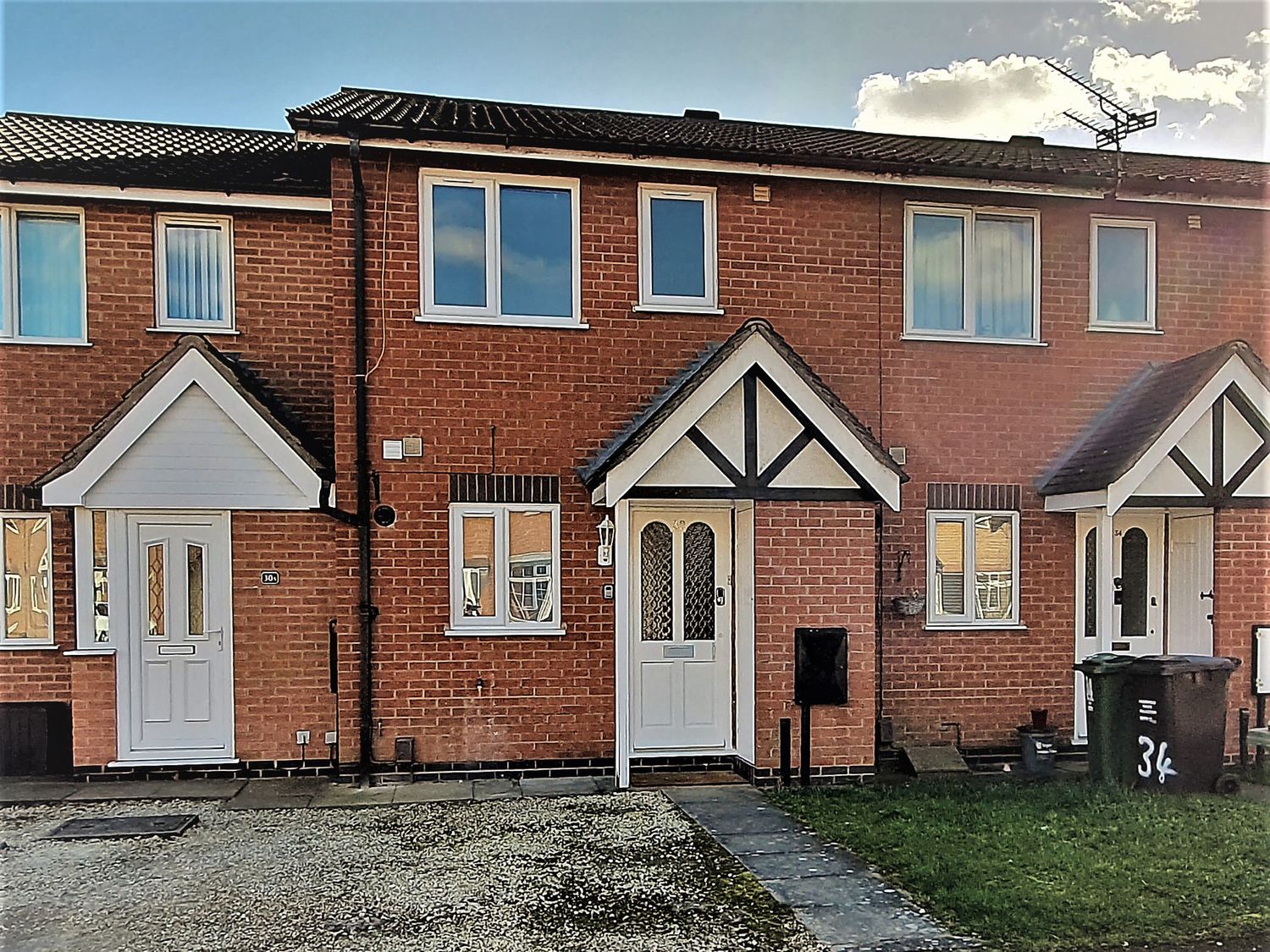 A brick house with front doors and a pathway at 32 Moorland House