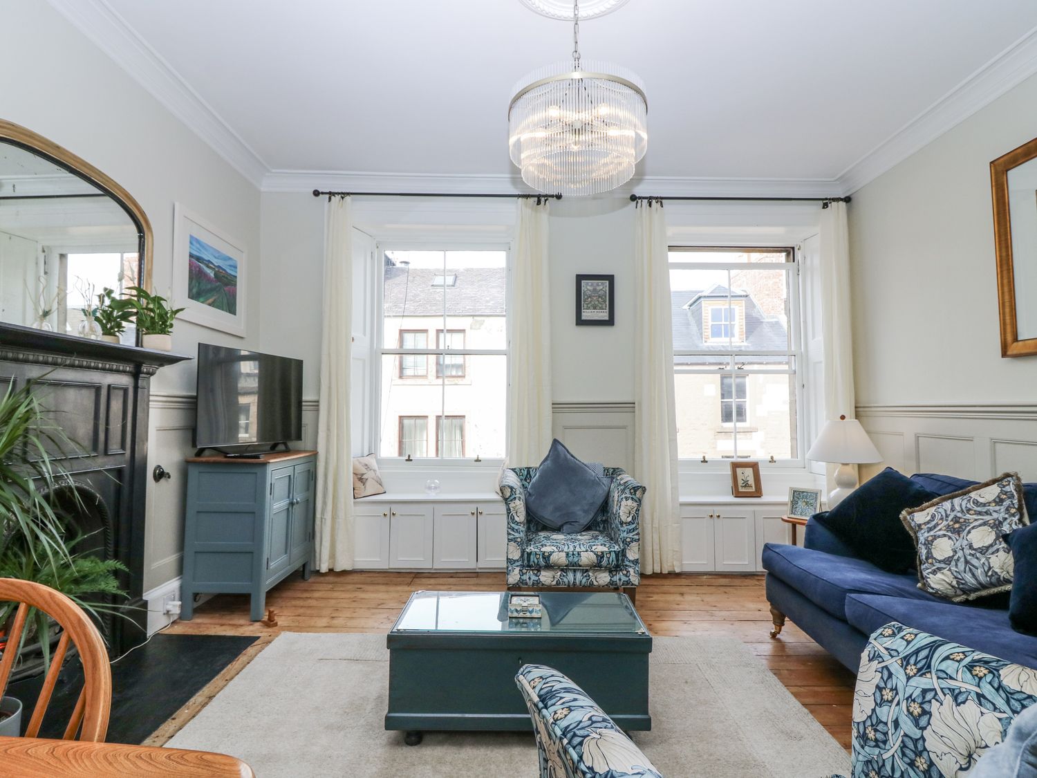 A living room with a sofa and television at 11A High Street in Jedburgh