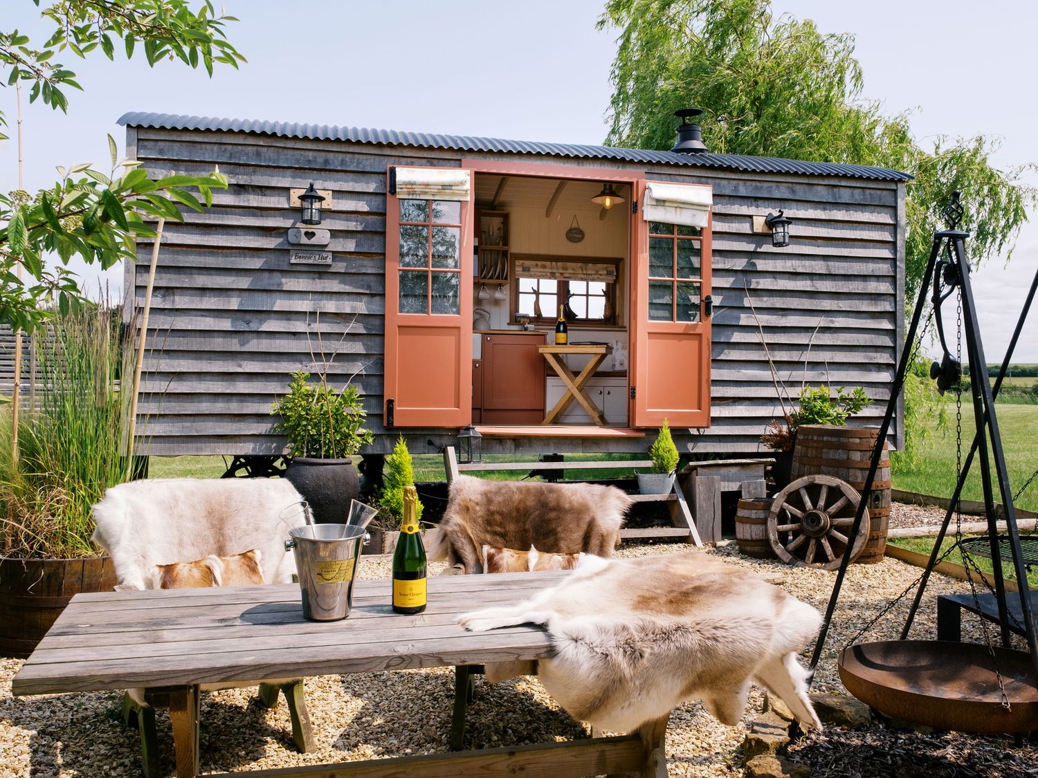 An outdoor area with a shepherd's hut and table set at Bonnie's Shepherds Hut at Shepherds Lodge Retreat and Wellness Bottesford near Redmile and Vale of Belvoir