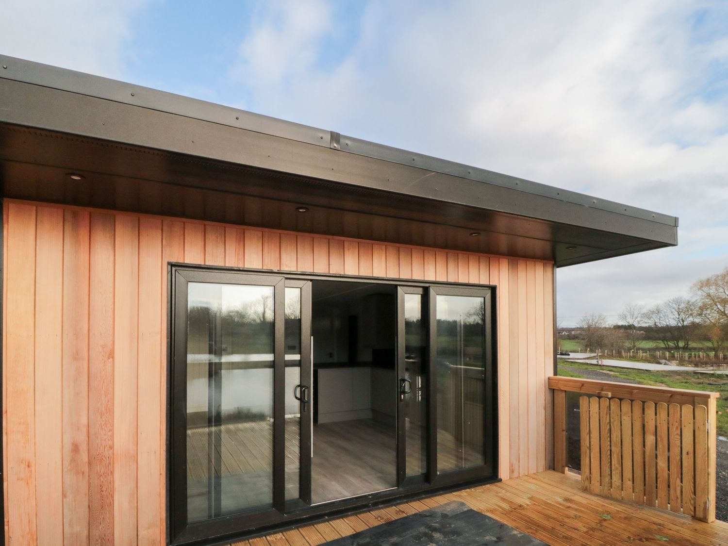 A deck area with sliding glass doors and wood paneling at Lodge 1 Yarm