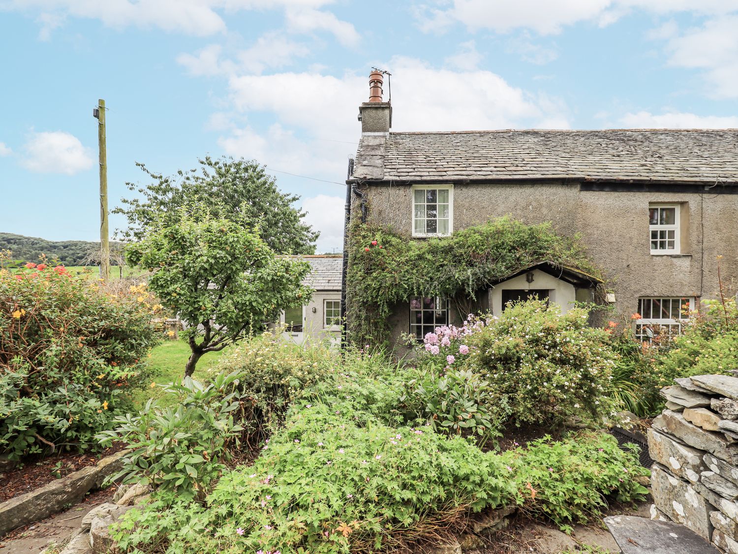 A garden surrounding a stone house at Old Cottage in Oxen Park near Ulverston