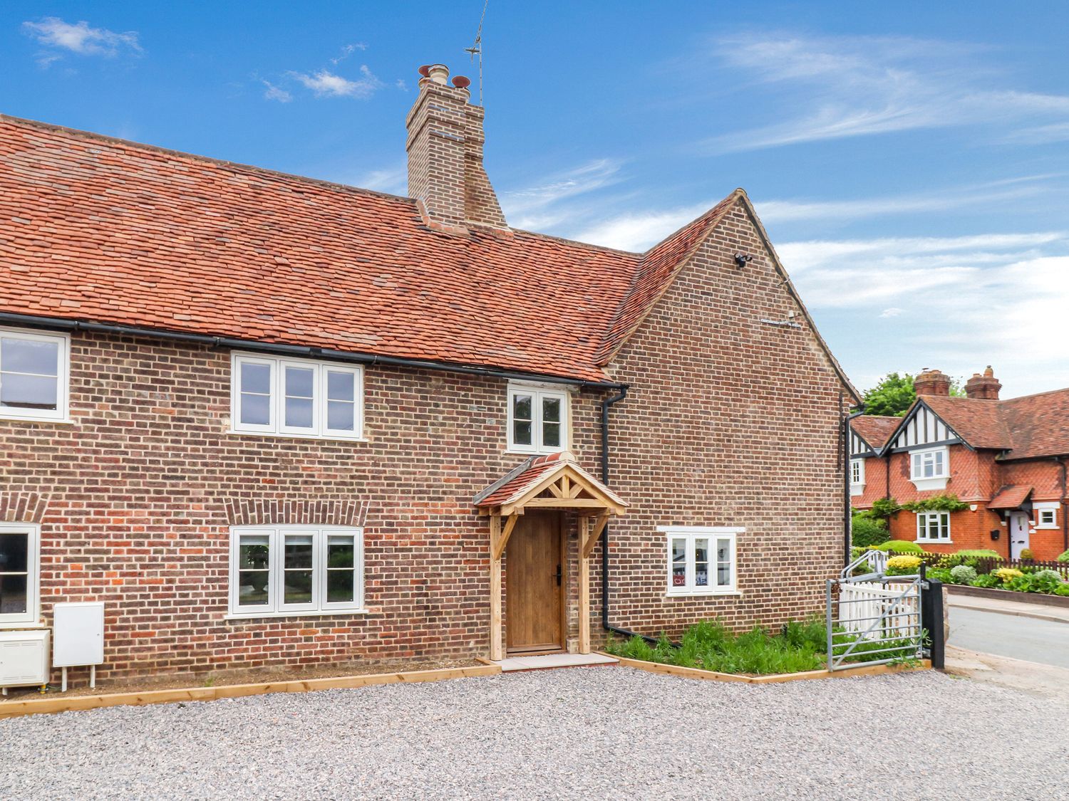 A house with a front door and gravel driveway at Tuffs Farm Cottage 1 in Kings Langley