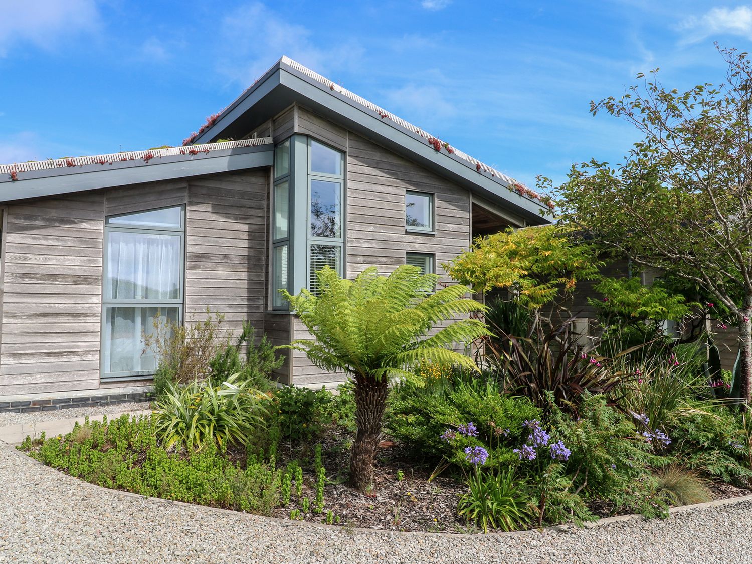 A house with large windows and a garden at Una, Lodge 70 Carbis Bay