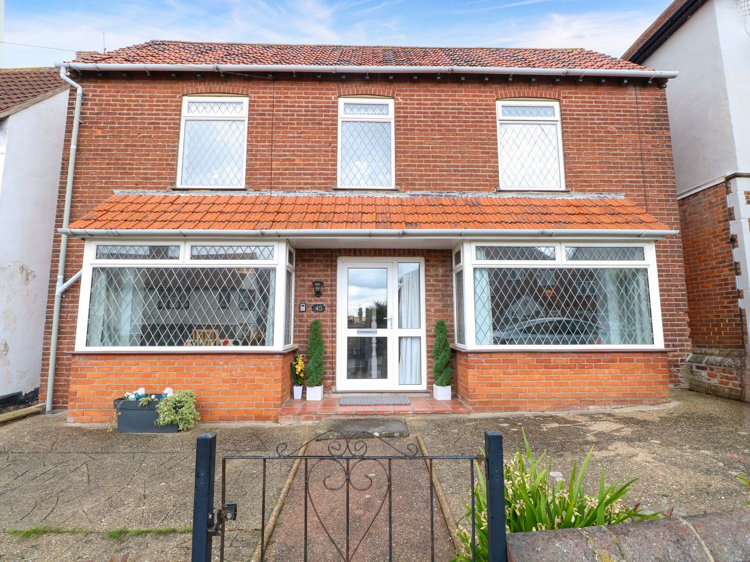 A brick house with windows and a front door at Highland House in Sheringham