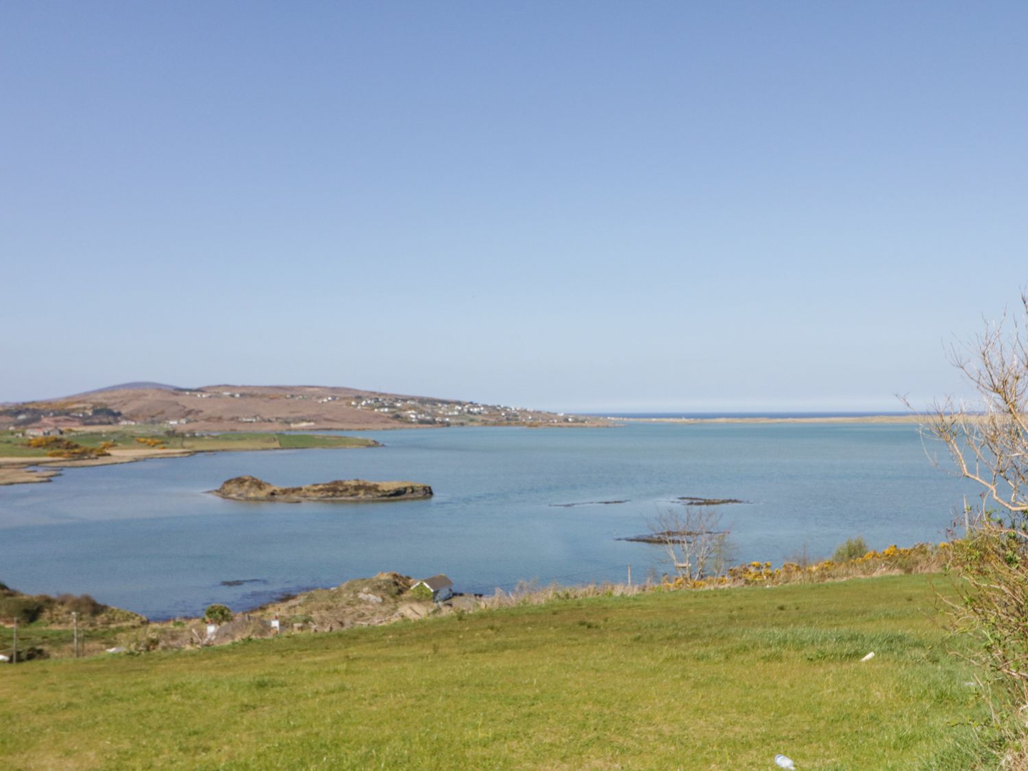 A coastal landscape with grassy foreground water and hills near Atlantic Sea Breeze Near Gortahork County Donegal