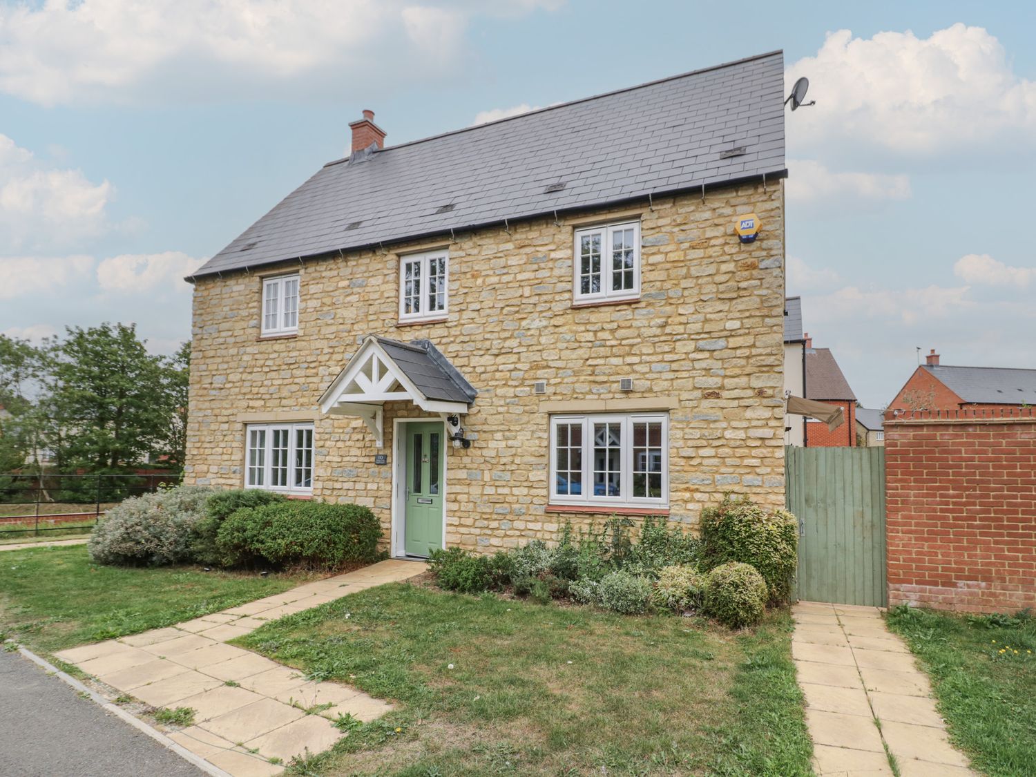 A house with a garden and pathway at Silverstone Paddock Retreat in Silverstone