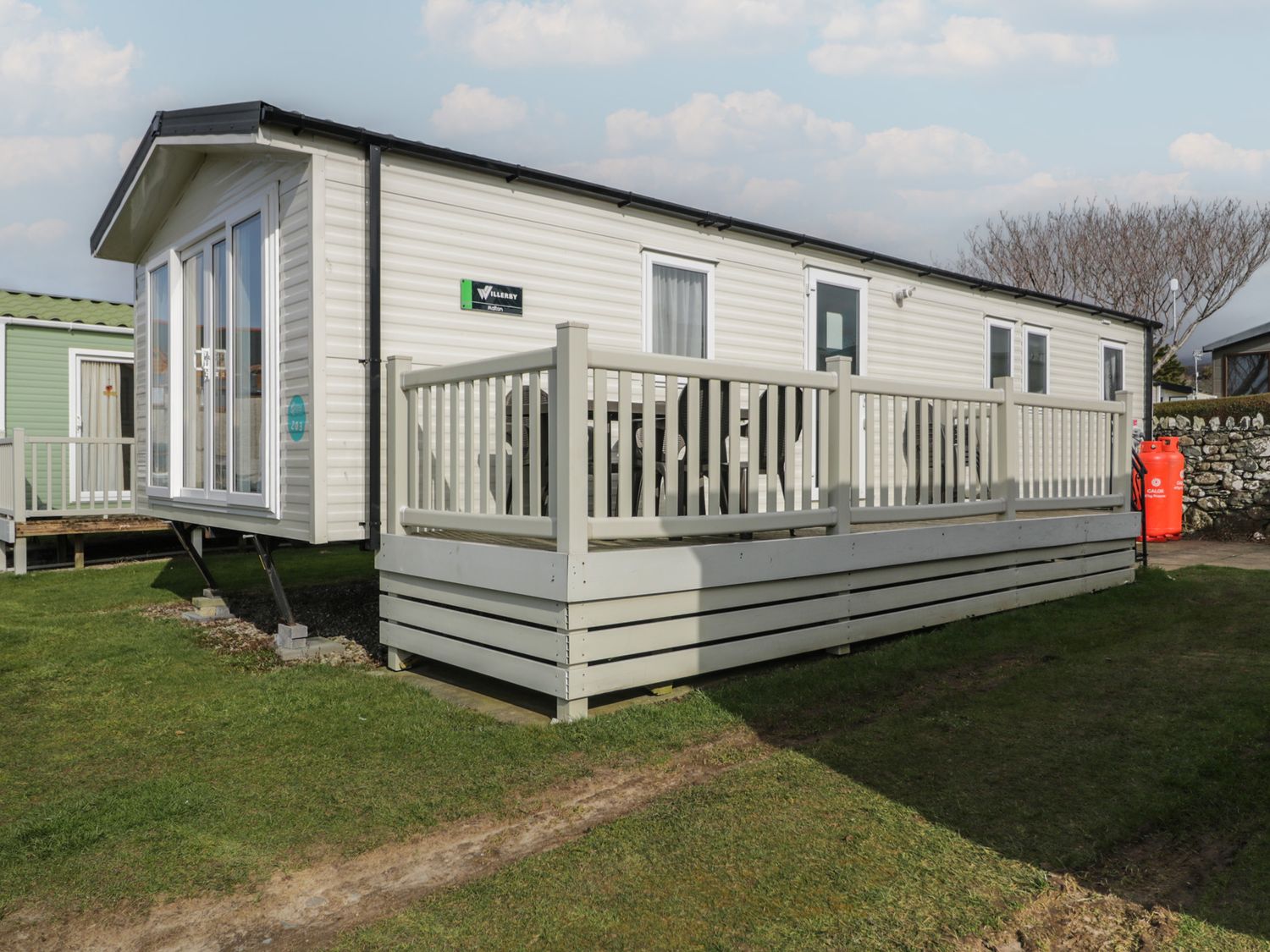 A caravan with a deck and outdoor seating at Gold Caravan (203) Talybont