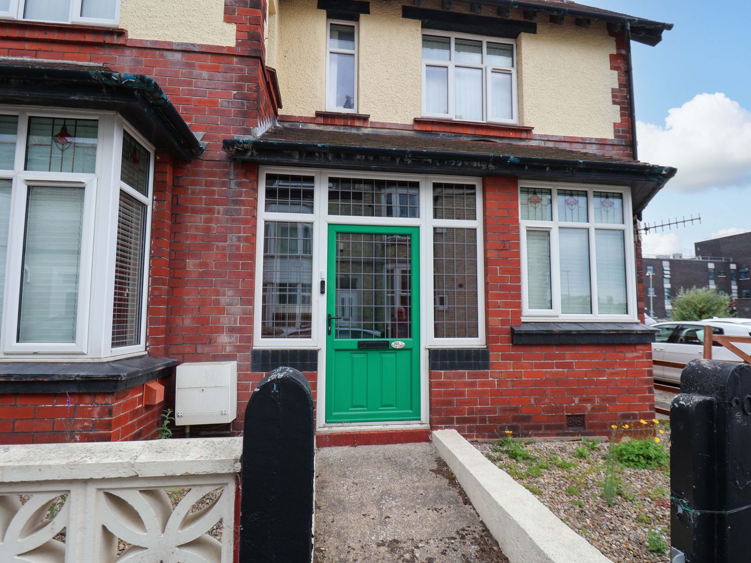 A front entrance with a green door and brick facade at Falcon's Nest in Whitby