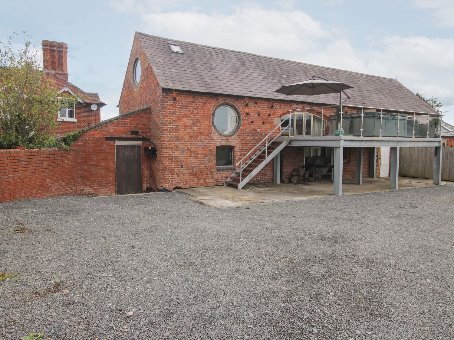 A brick building with a balcony and stairs at Millstone Cottages - Breidden View