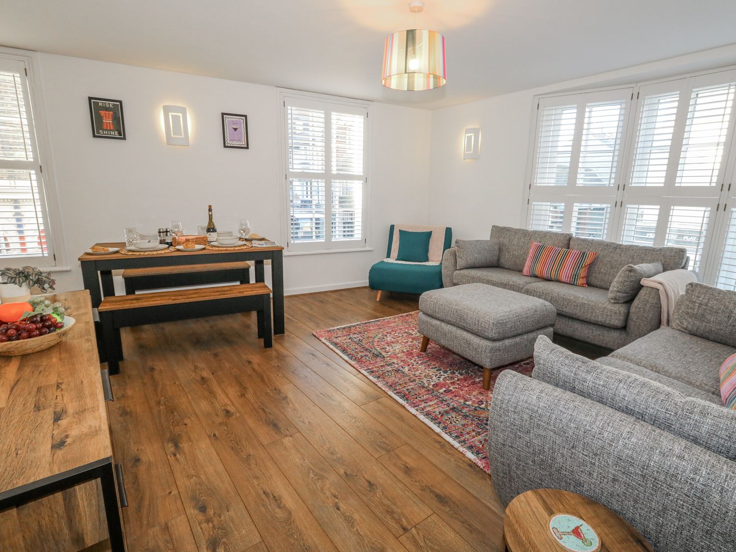 A living room with a sofa and dining area at Betty's Buoy Weymouth