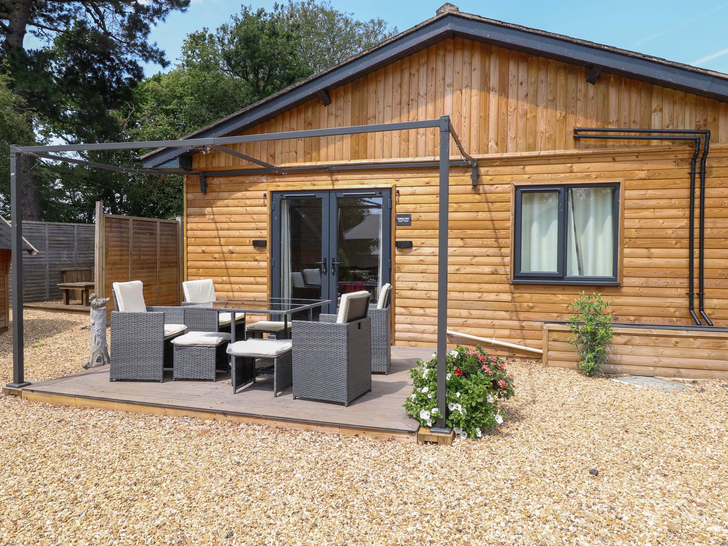 A patio with chairs and a table at Robin's Nest Lodge Snettisham