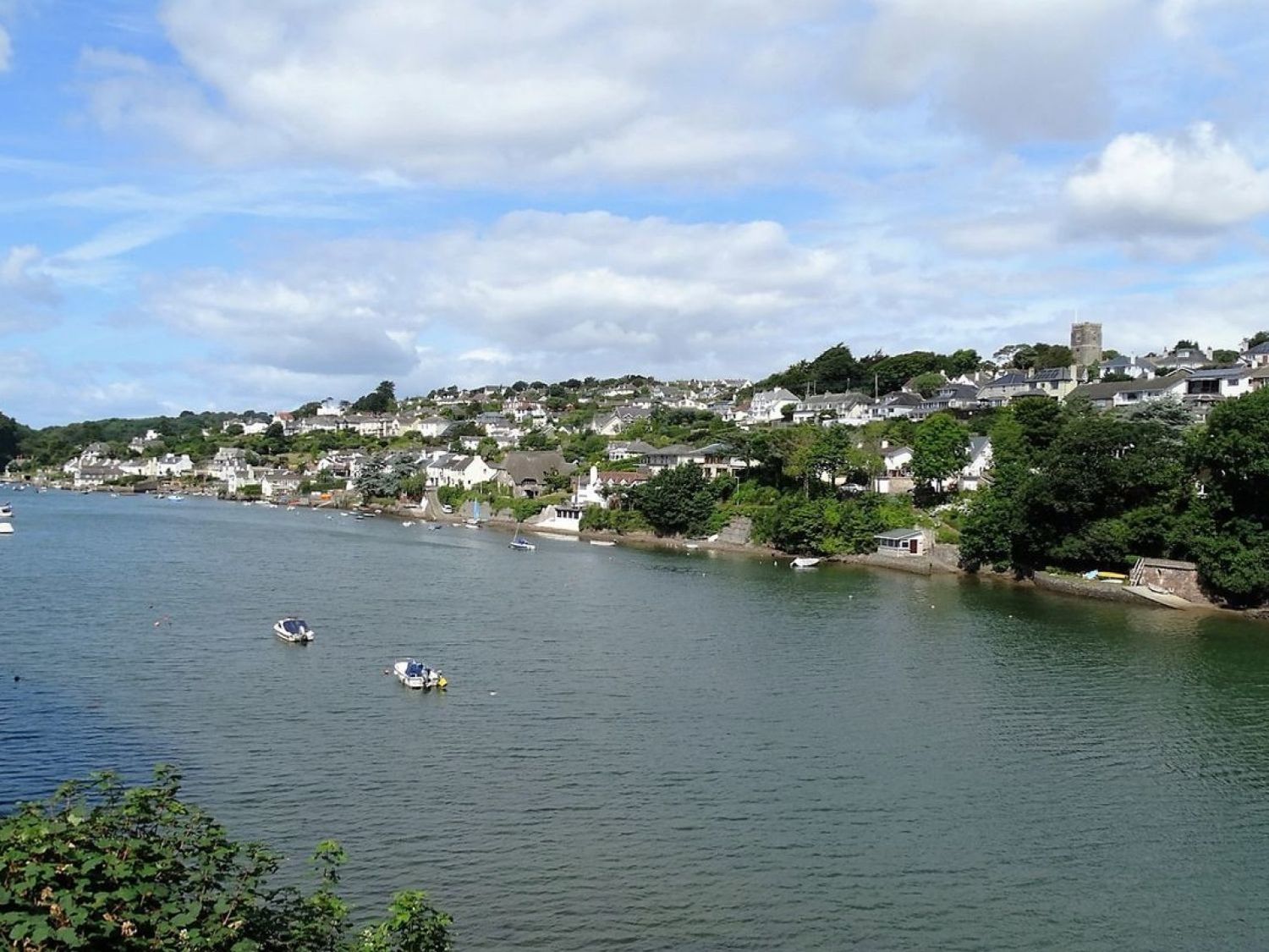 A river with boats and houses along the shore at Matilda Lodge in Newton Ferrers