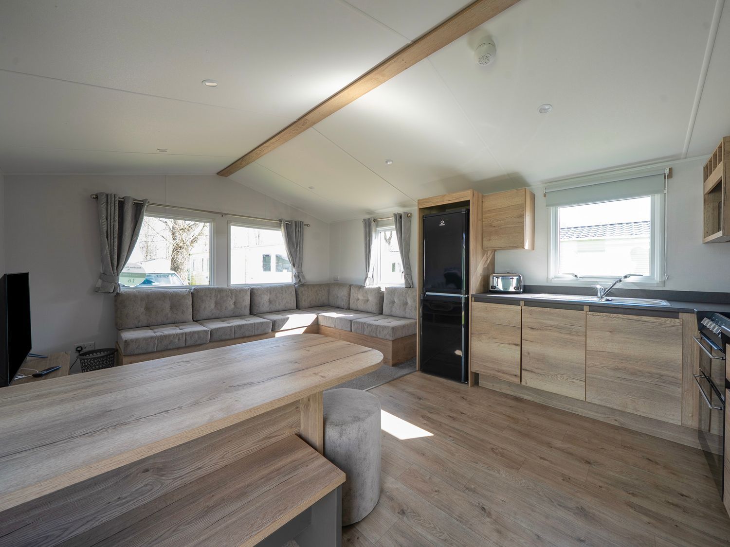 A living room with a sofa and kitchen area at Billy’s Way  - Hayling Island
