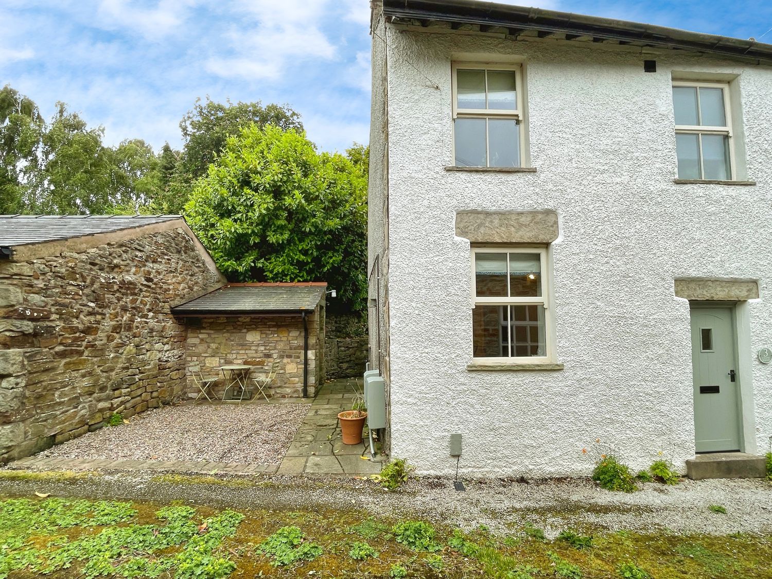 An outdoor area with a side view of a white house at 3 Chapel Square in Brookhouse near Caton