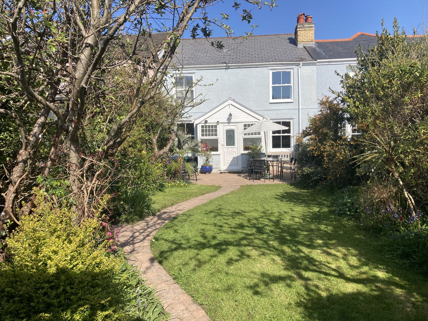 A garden with a house and seating area at 5 Bed Cottage Mumbles in Mumbles