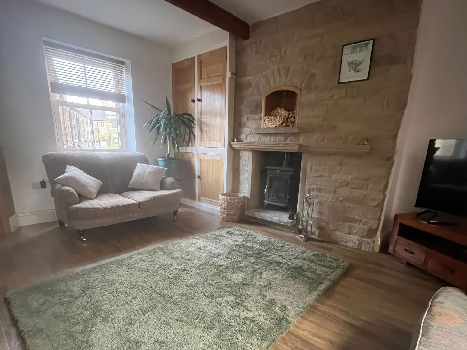 A living room with a sofa and fireplace at 12 Queen Street in Keighley