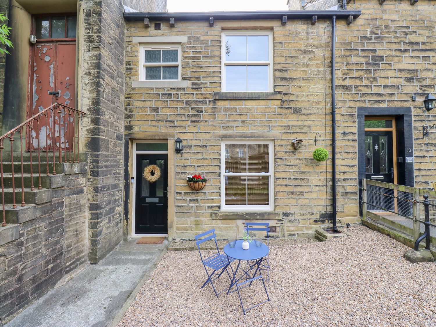 An outdoor area with a table and chairs at Hivewood Cottage in Haworth