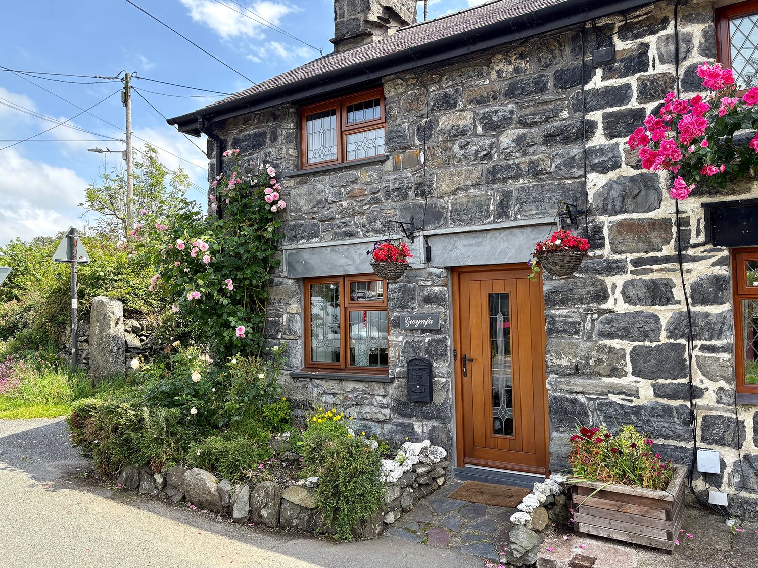 The entrance of Gwynfa with flowers and stone features in Ysbyty Ifan