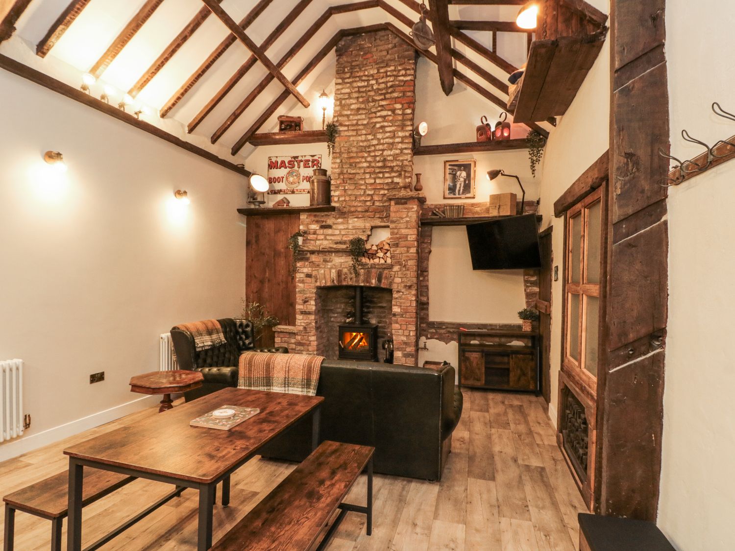 A living room with a fireplace and television at Dotty's Den in Bridlington
