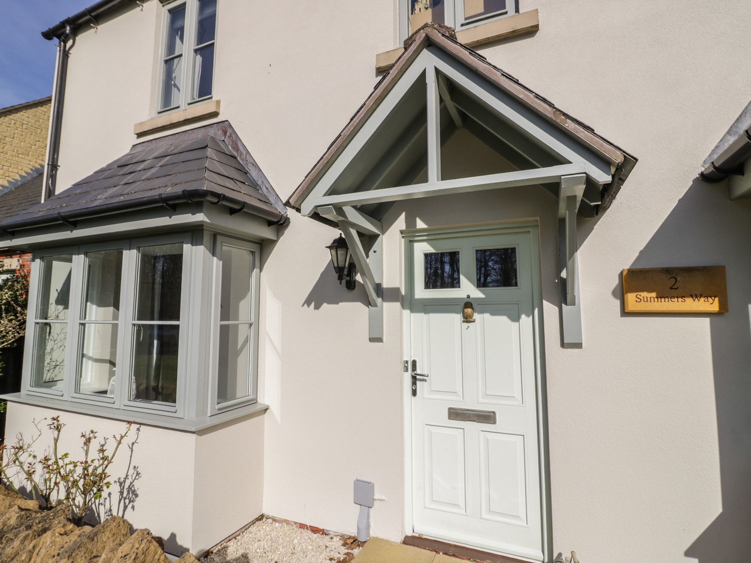 Front door entrance with a small porch and bay window beside it at 2 Summers Way in Moreton-In-Marsh