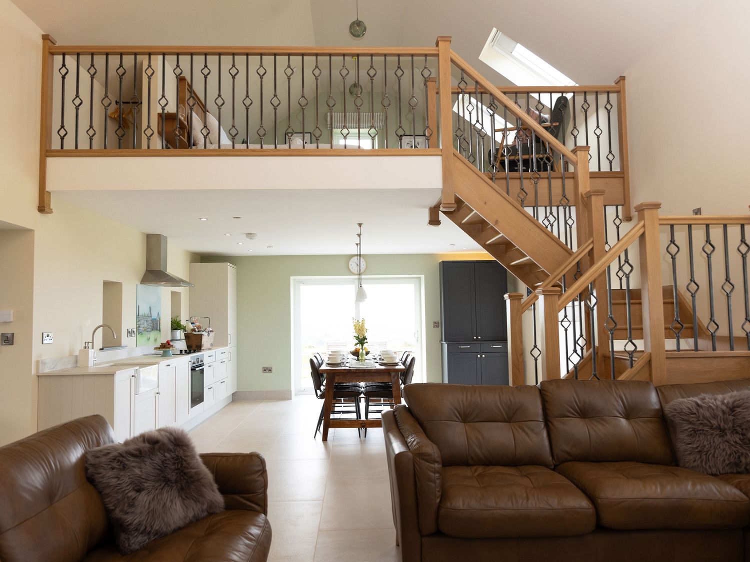 A living room with a staircase and dining area at Golygfa Cwrt, Talybont