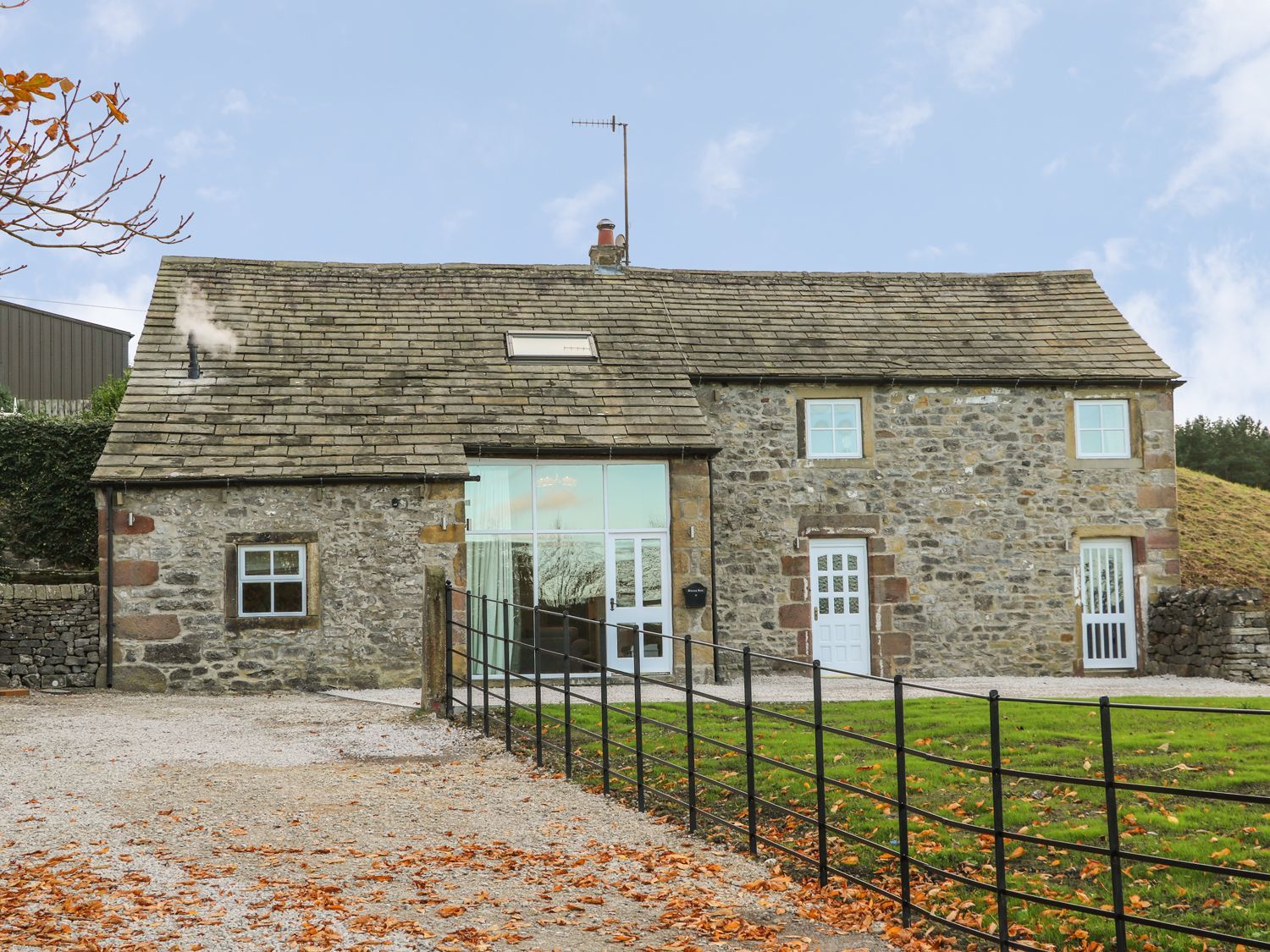 A stone house with a front yard and fence at Fogga Croft in Skipton