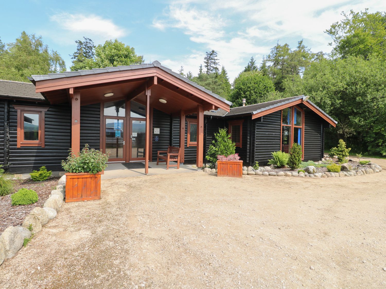 A house entrance with planters and trees at Shore Lodge in Brodick