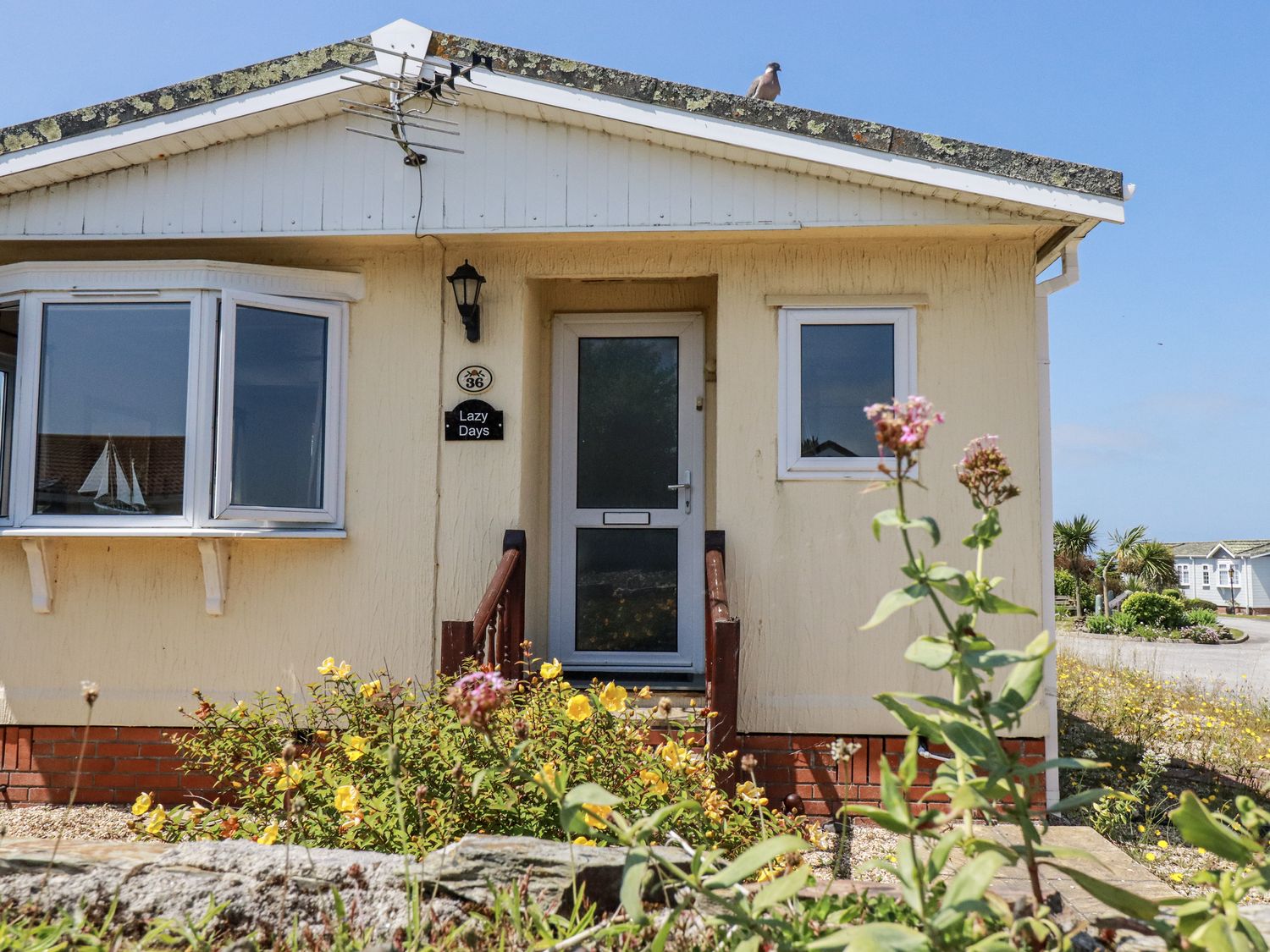 A house exterior with a sign at Lazy Days in St Merryn