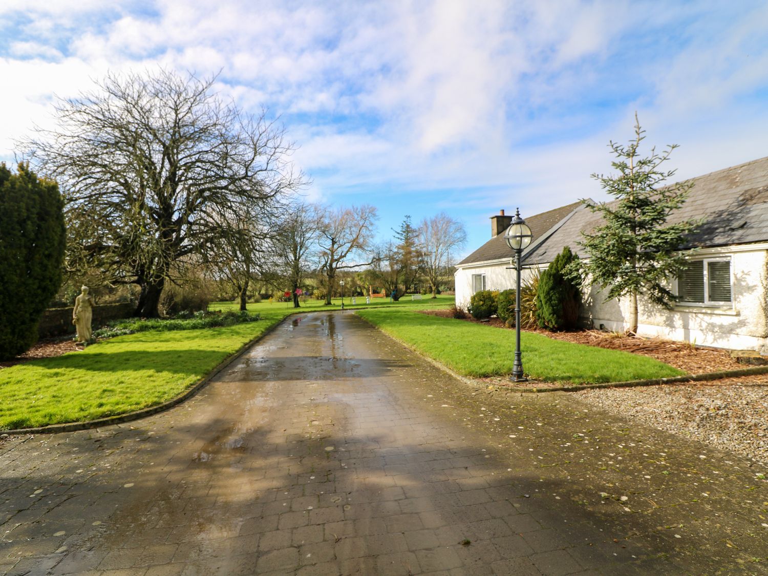 A driveway with a lamp post beside a house and trees on both sides at The Dairy in Clonsharragh near Duncannon County Wexford