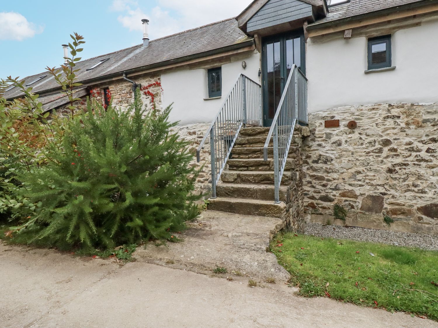 An entrance with steps and a door at Coombe Barn in Cusgarne near St Day