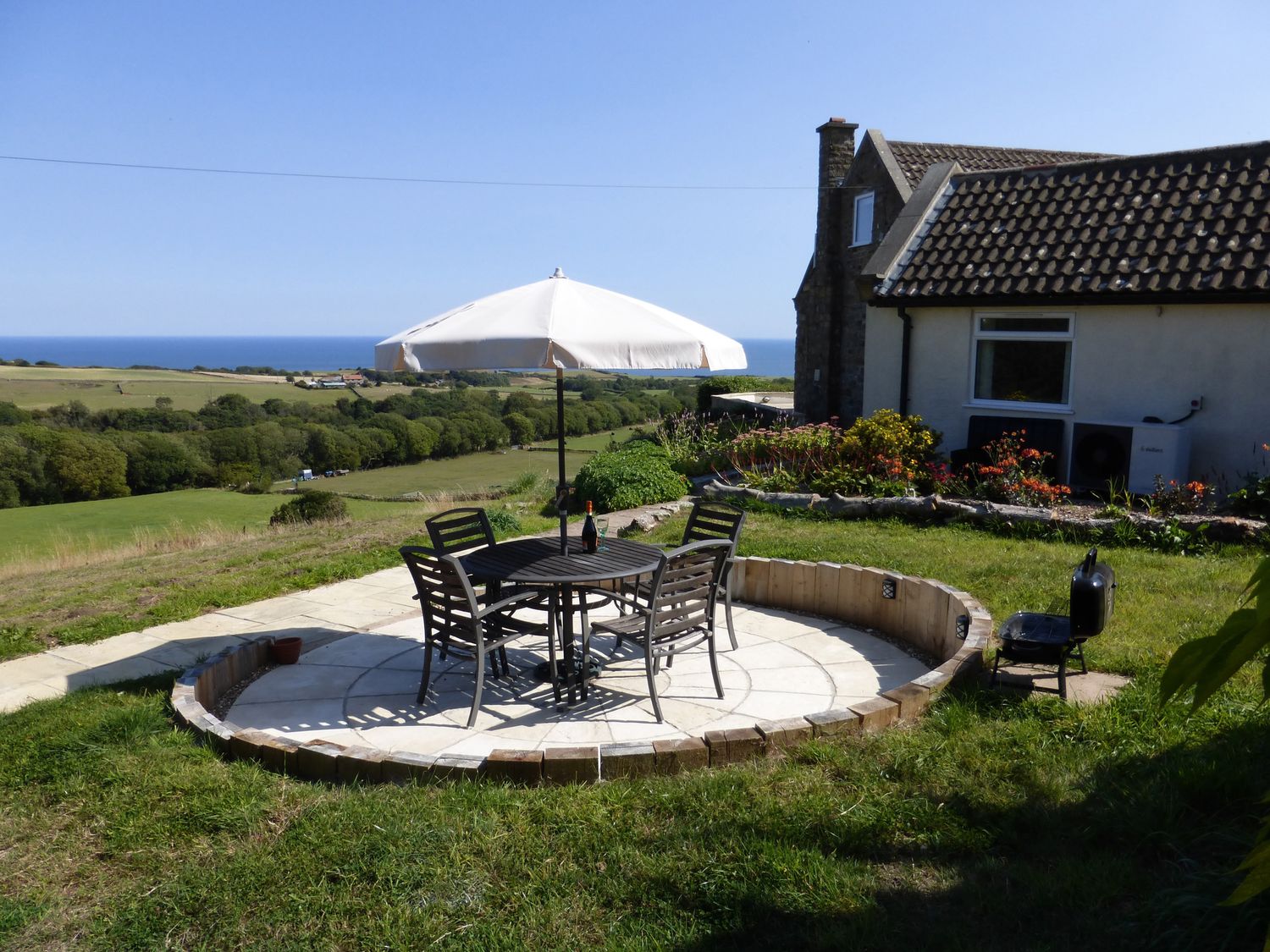 An outdoor seating area with a table and chairs at Meadow Cottage in Staintondale near Cloughton