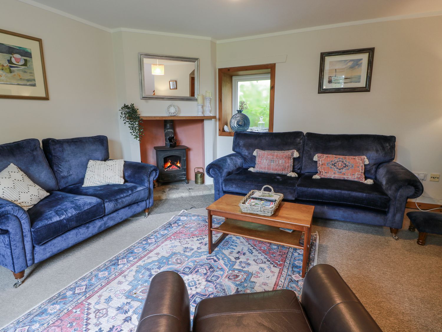 A living room with sofas and a fireplace at The Steading in Castle Douglas