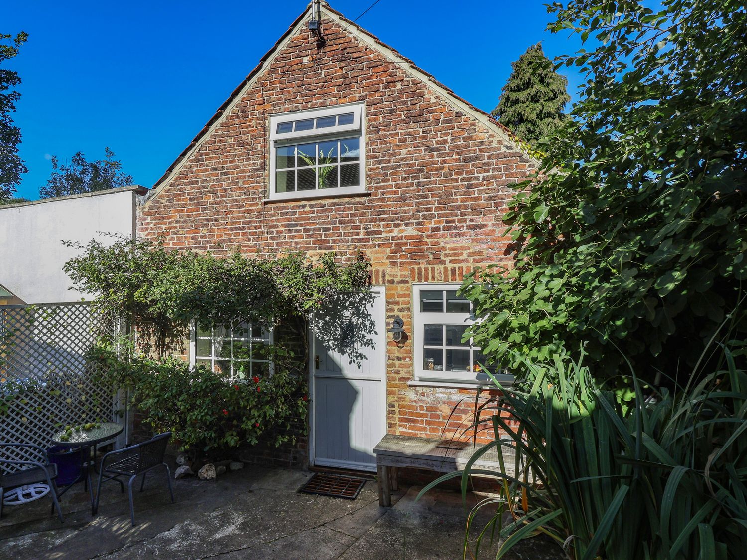 An outdoor area with brick exterior and seating at Figgy Cottage in Ripon