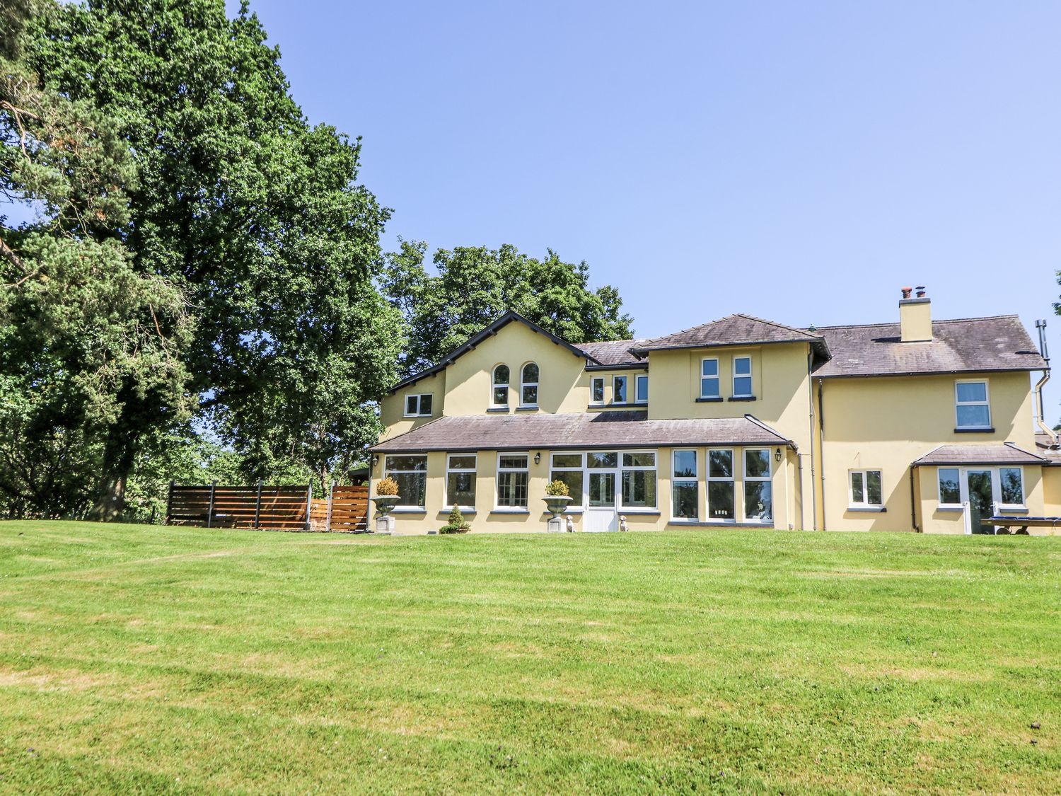 A house with windows and grass area at Glanrannell Park House Llanwrda