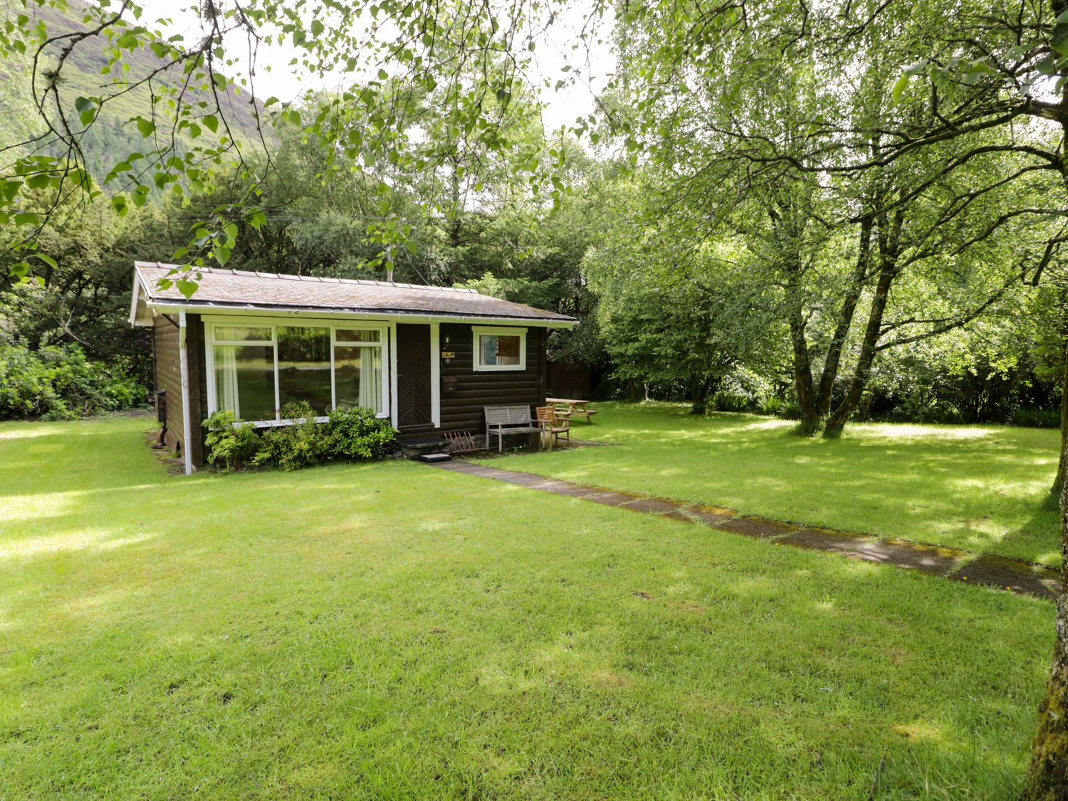 A cabin with a pathway and chairs in a garden at Ty Bedwen Dinas Mawddwy