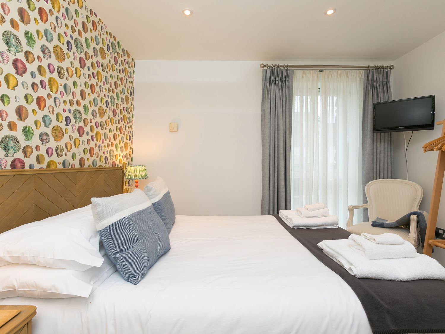 A bedroom with a bed and television at Far Cliffs in St. Ives
