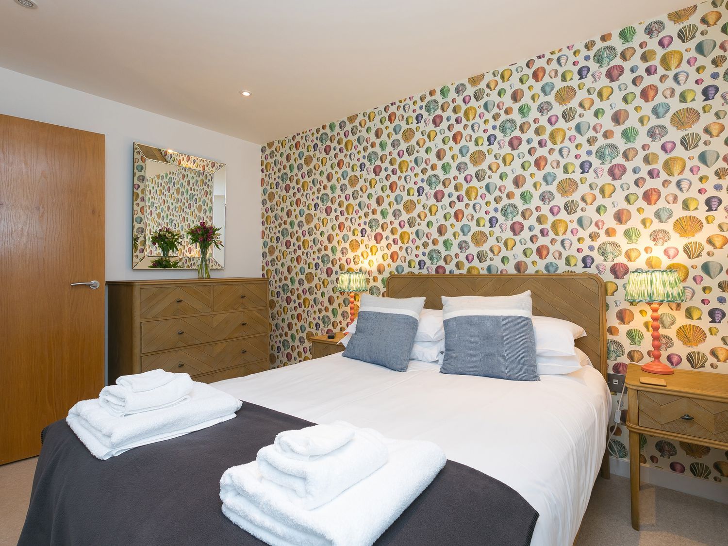 A bedroom with a bed and dresser at Far Cliffs in St. Ives