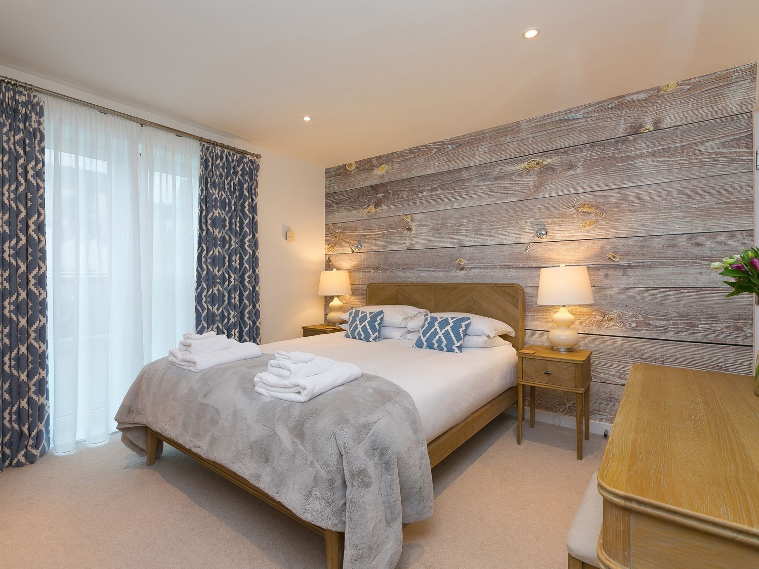 A bedroom with a bed and curtains at Far Cliffs St. Ives